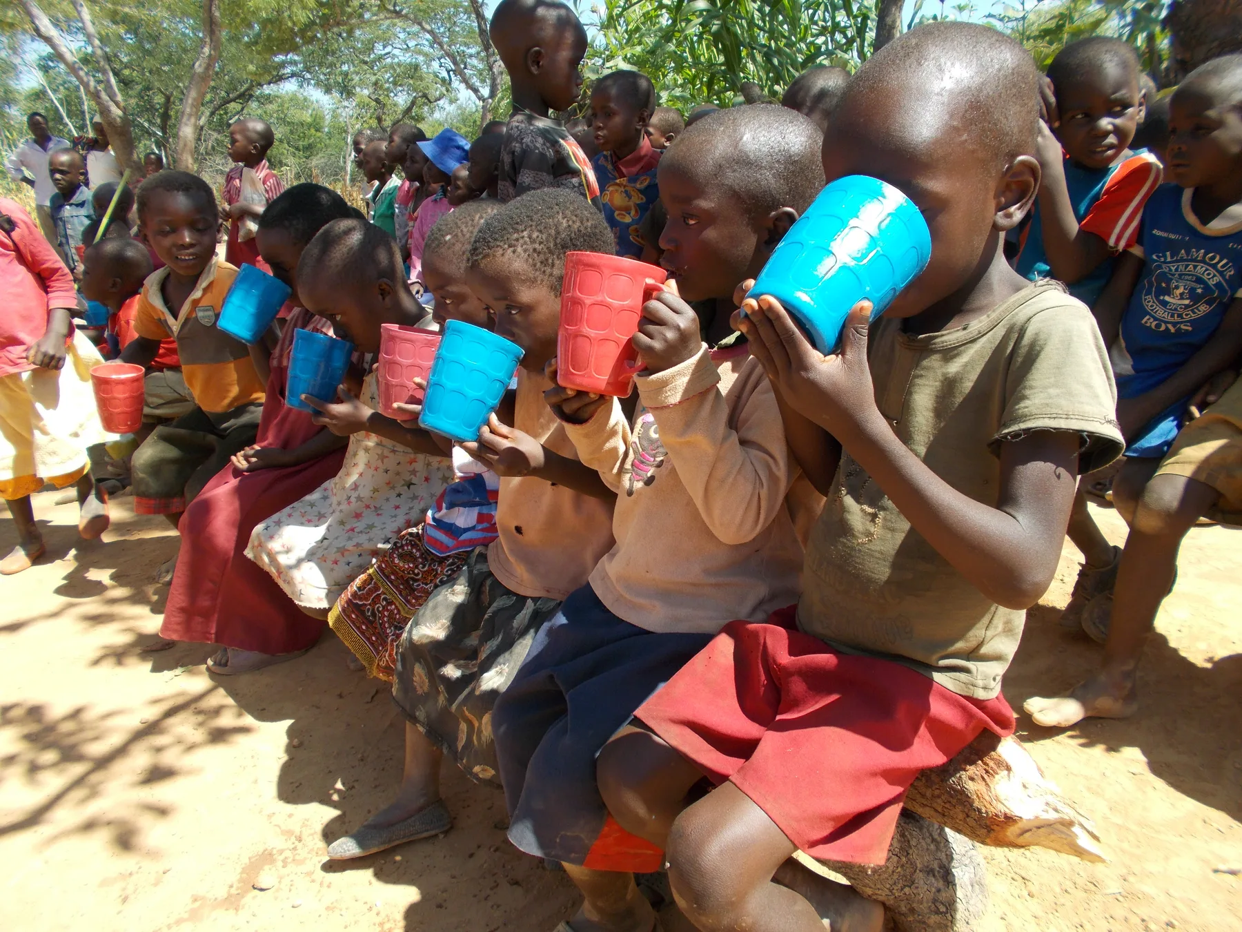 Children receiving drinks during a community support activity